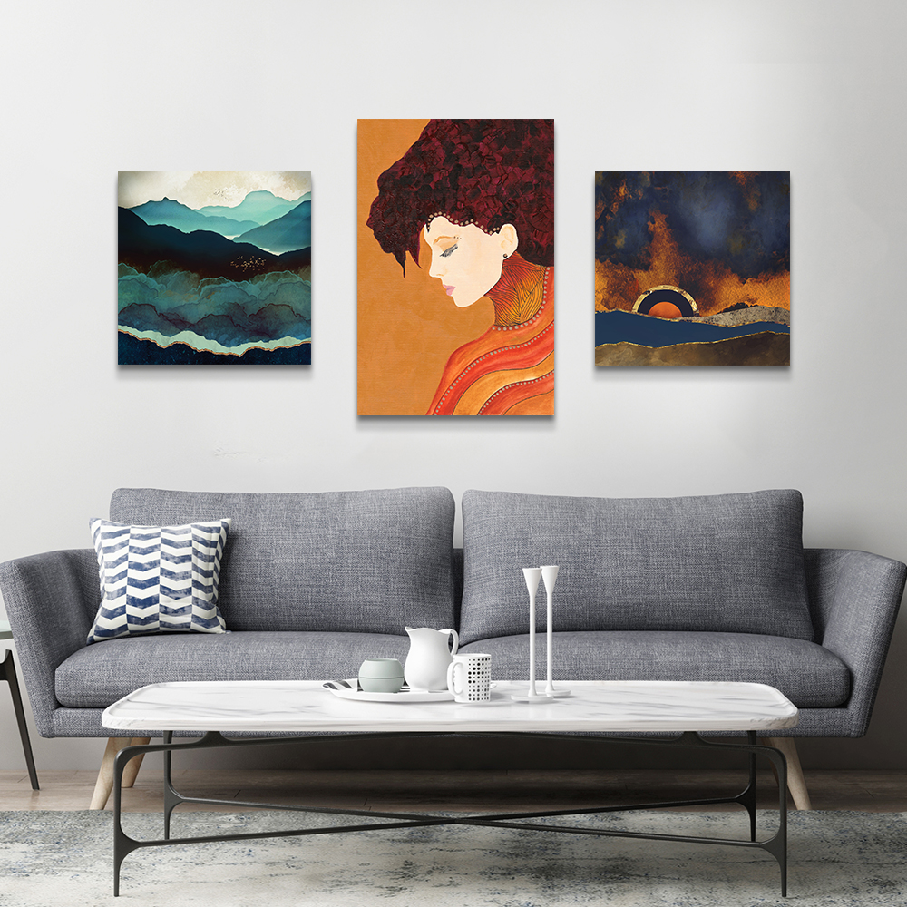 Grey living room with three canvas prints: Indigo Mountains by SpaceFrog Designs, Anne by Viviana Gonzalez, and Before the Storm by SpaceFrog Designs