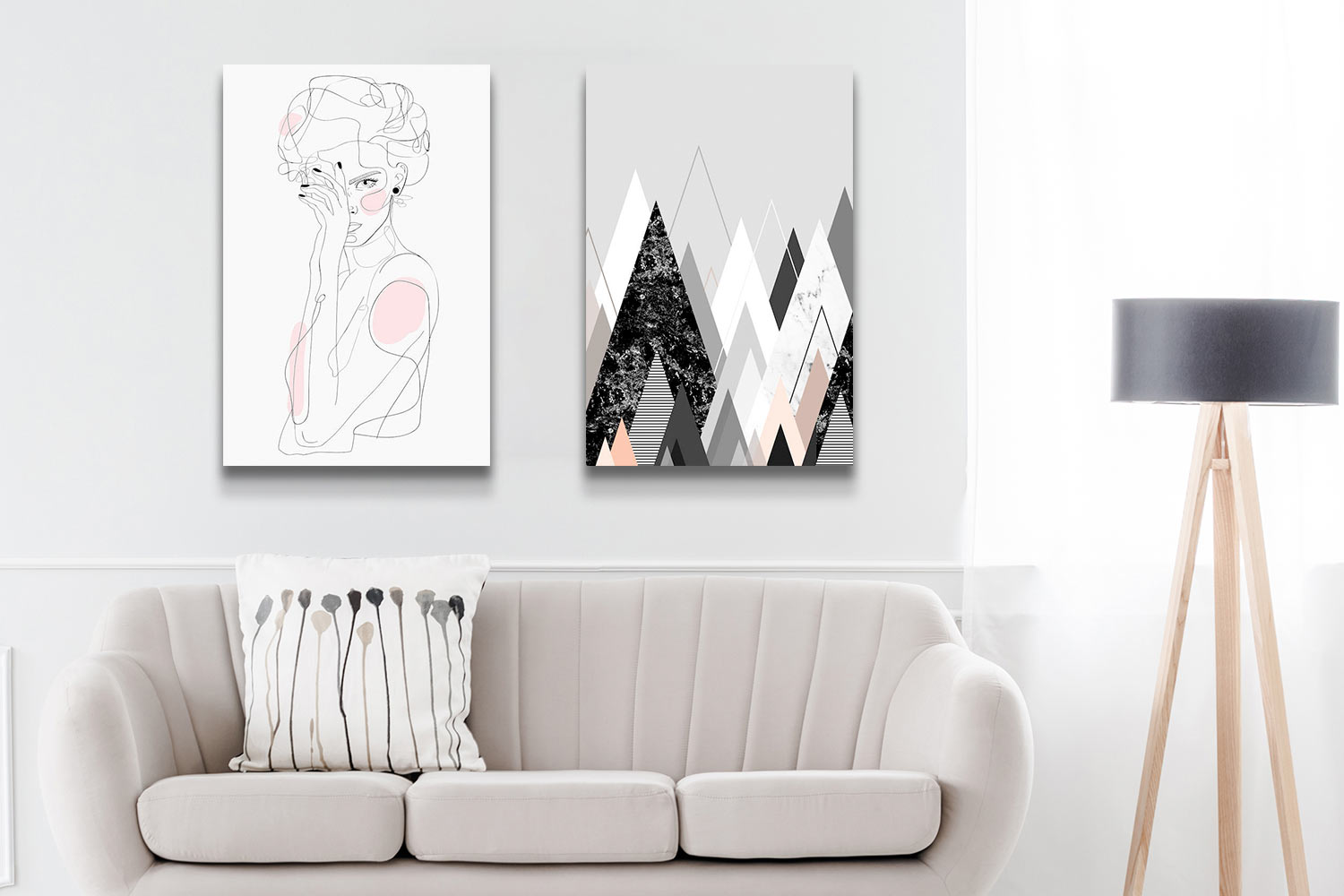 A greige living room with two minimalist, neutral canvas art prints above the sofa: "Freaq Sista" by Nettsch and "Graphic CXXIV" by Marieke Böhmer