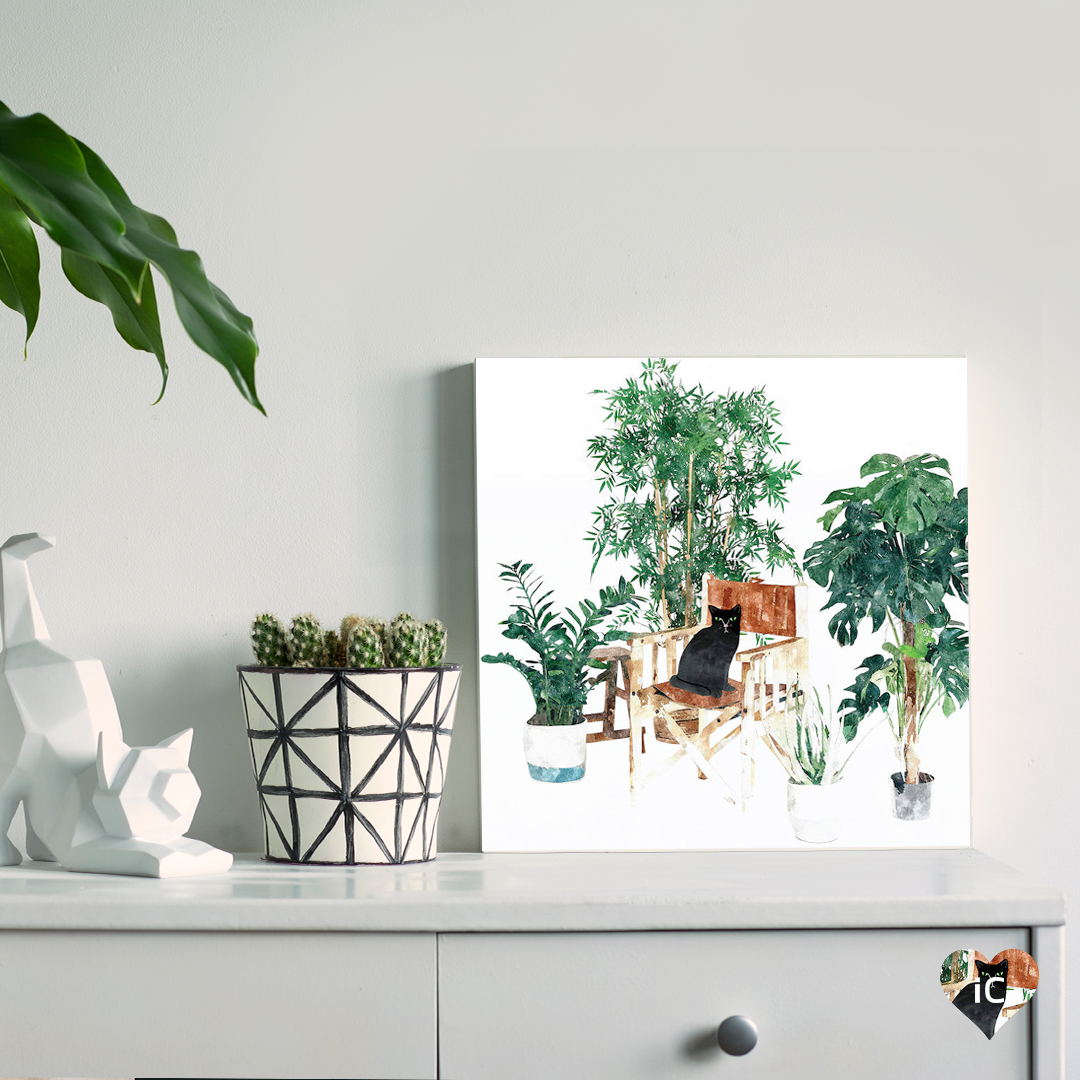 black cat sitting on a director chair surrounded by house plants