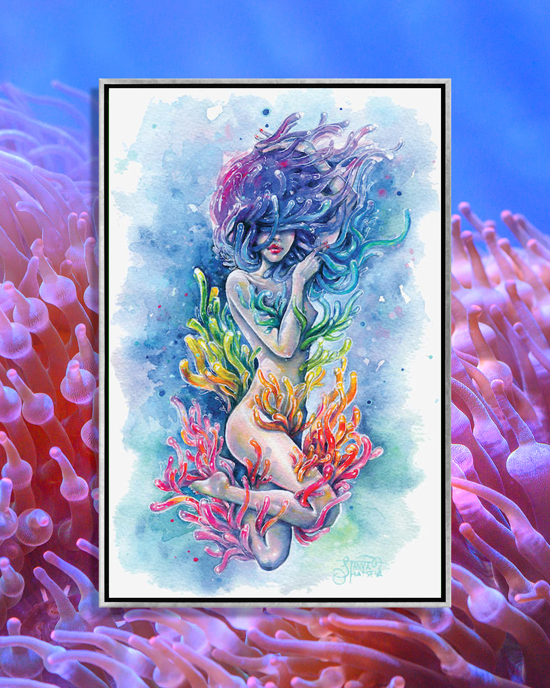 woman in water surrounded by rainbow coral including her hair
