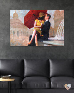 woman holding a red umbrella wearing a yellow dress and hat sitting on man who&#039;s wearing a suit&#039;s lap while kissing near a fountain