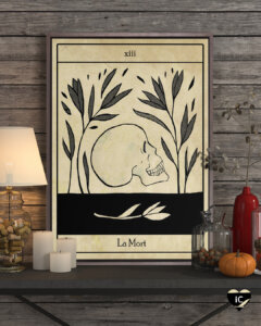 Graphic of a tarot-card like image of a skull with text that says "La Mort" framed on a shelf with pumpkins, candles and vases