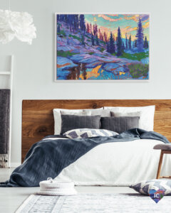 Colorful mountain landscape under sunset with tall trees framed in white in a bedroom with white bed and wood bedframe