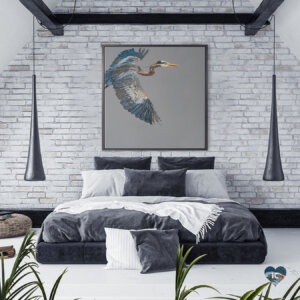 a large blue heron flying into the frame against a stark gray background