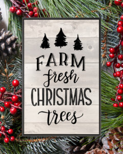 Gray shiplap sign that says "Farm Fresh Christmas Trees" with outlines of three black trees with a black frame