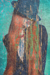 Distressed graphic of a woman with long red hair wearing a fedora covering her eyes on a green background