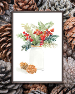 White mason jar with holly and mistletoe in it near to two pine cones on a white background with a dark wood frame
