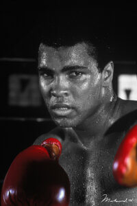 Black and white photo of Muhammad Ali with red boxing gloves in a boxing stance