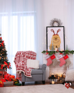 Graphic of a Pomeranian wearing a candy cane hat with a candy cane in its mouth framed on a mantle in a living room with a Christmas tree, presents, and a holiday blanket