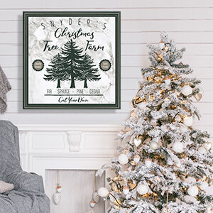Vintage sign that says "Snyder's Christmas Tree Farm" with green text hanging on a white shiplap wall over a fireplace in a room with a white and gold Christmas tree and a gray chair