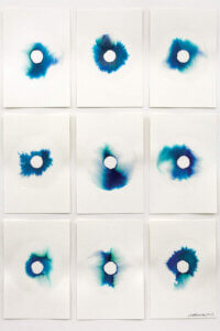 A series of nine linen surfaces each with a variation of a blue circular stain