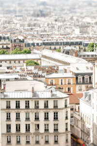 “Paris Rooftops” by Ruby and B shows the rooftops of neutral-colored buildings in Paris.