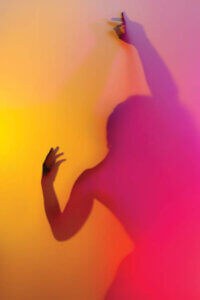 “Rainbow Lover II” by Elena Kulikova shows a person obscured from focus in a dance-like position between a pink and orange ombre.