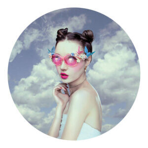 “Oblivion” by Natalie Shau shows a woman wearing space buns and pink sunglasses decorated with birds and flowers with clouds in the background.