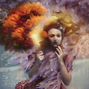 Gracie by Lola Mitchell showcases a woman underwater with bubbles coming from her mouth surrounded by floral-like waves