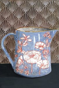 Wall art of a blue vase with white and pink flowers against a patterned background by iCanvas artist Miri Eschet