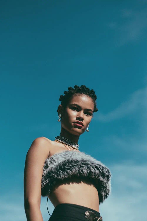 Photographed portrait of a black woman in fur tube top with blue sky overhead by Giancarlo LaGuerta