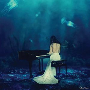 Art trend 2021 wall art of a woman in a white dress playing piano in the ocean