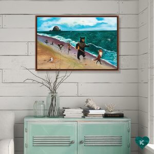 White paneled wall above teal cabinet with framed wall art of woodland creatures running along the beach