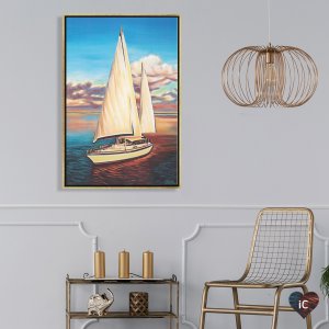 Gold framed painting of a white sailboat against a blue, pink and orange cloudy sky hung above a bar cart