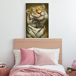 Framed portrait above pink bed of a smiling tiger with closed eyes by iCanvas artist Patrick LaMontagne