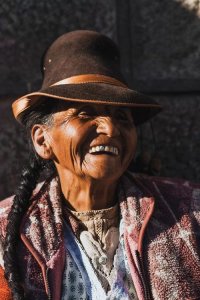 Authentic photo of a Peruvian merchant with a hat and braid laughing by iCanvas artist Luke Anthony Gram