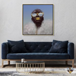 Framed portrait of Black woman with gold sunglasses, gold lips and cloud-like shirt by Adekunle Adeleke mounted above blue couch