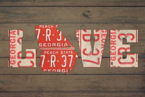 Georgia Home Decor featuring red Georgia license plates as letters spelling &quot;LOVE&quot; against wood by icanvas artist Design Turnpike
