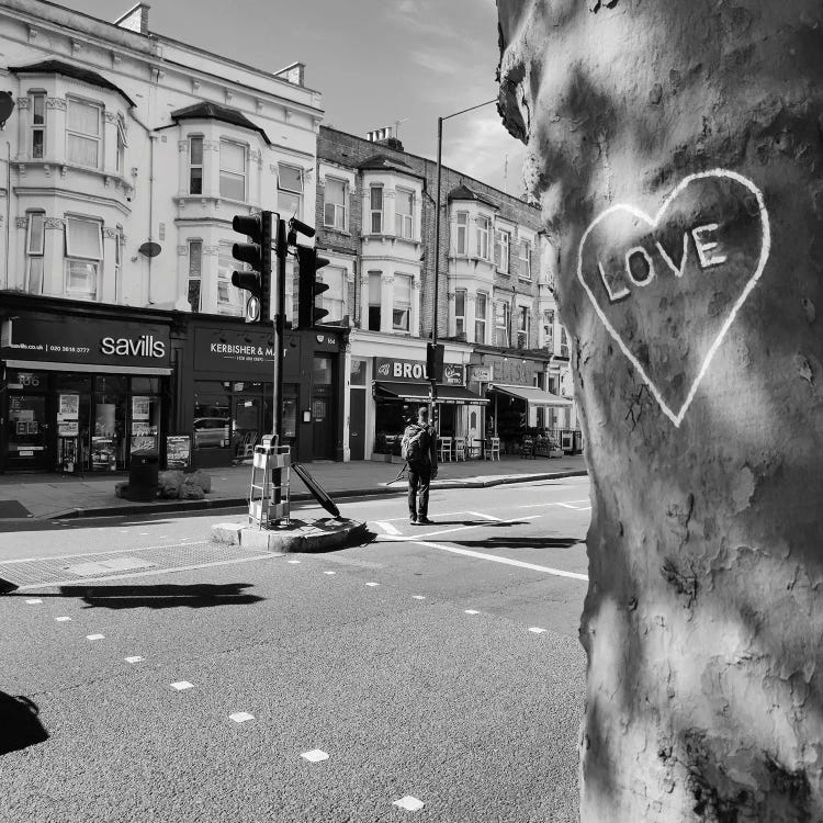 black and white photography of a city street in front of wall with heart and word "love" on it by new creator Amadeus Long