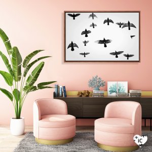 Framed wall art of a flock of black birds against white sky by icanvas artist Martin Henson mounted in pink room