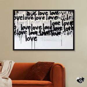 Black and white graffiti art of words "love" framed above red couch by iCanvas artist Kent Youngstrom