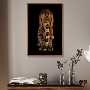 Framed photograph of a Malayan tiger&#039;s tail and backside mounted above table with vases and book by iCanvas artist Joel Sartore