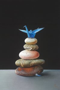 Stones stacked on top of each other with a blue paper crane on top