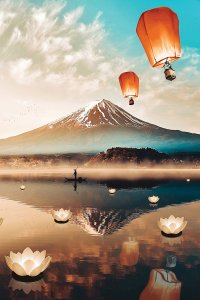 A snowy mountain behind reflective water with floating lanterns