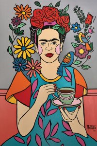 Frida Kahlo holding a cup of coffee and surrounded by flowers and birds.