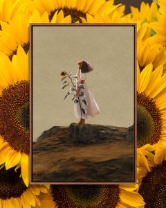 Black woman standing on mountain holding giant sunflower