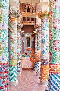 Colorfully patterned pillars surrounding large flamingo poking its head out