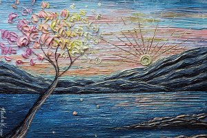 NKH123 Trees with pink and yellow flowers in front of water and mountains