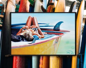 Woman laying on top of boat with surfboards