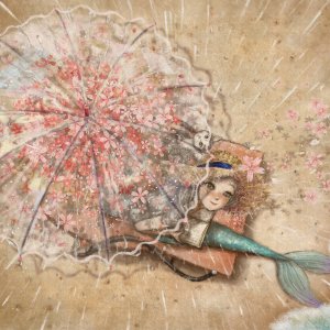 Mermaid sitting under umbrella on the beach with book in lap looking up