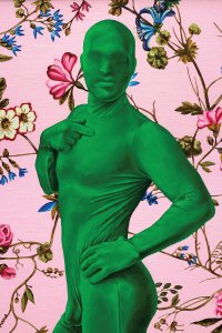 Man in full green suit posing in front of floral background