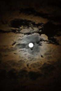 A dark cloudy sky with a full moon in the center