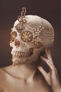 Portrait of a person with a skull head full of pearls and jewels