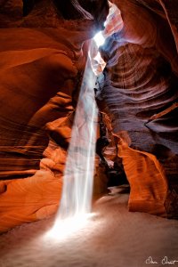 A stream of sunlight shining through a hole into the inside of a canyon