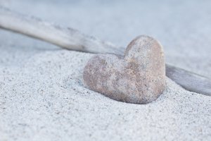 Stone Heart Beach Still heart shaped stone sitting in the sand