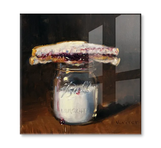 Half of a peanut butter and jelly sandwich on top of a mason jar full of milk