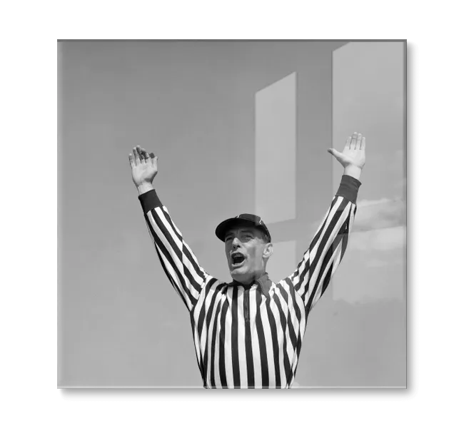 Man in black and white striped shirt with his hands in the air