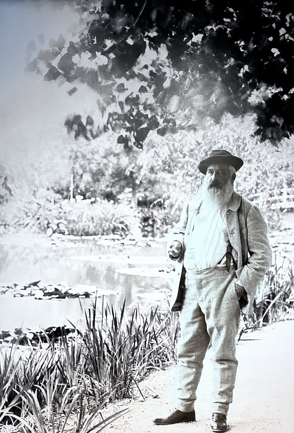 claude monet standing by water lily pond