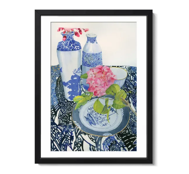 tablescape with mixed patterns, vases, a plate and a pink flower