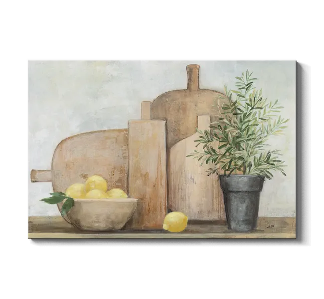wooden cutting boards behind a bowl of lemons and a green plant